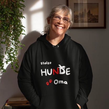 Frau trägt einen schwarzen HigherBlanks Premium Hoodie mit dem Aufdruck „stolze HUNDE Oma“, Hundesilhouette und Pfoten.